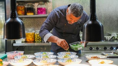 a man in a kitchen preparing food in bowls at Hotel Indigo Brussels - City by IHG in Brussels
