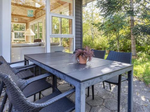 a wooden table with chairs on a patio at Tranquil Waterside Retreat-By Traum in Thyholm