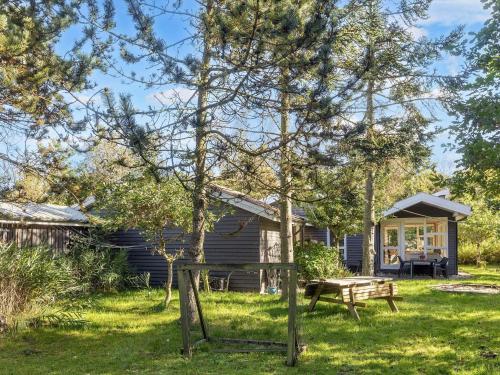 a cabin with a picnic table and a bench in the yard at Tranquil Waterside Retreat-By Traum in Thyholm