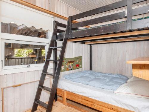 a bunk bed in a room with a ladder at Tranquil Waterside Retreat-By Traum in Thyholm