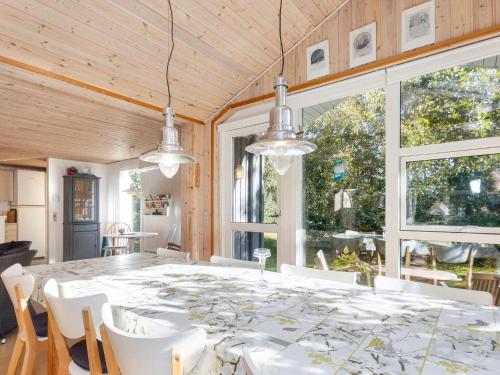 a dining room with a large table and white chairs at Tranquil Waterside Retreat-By Traum in Thyholm