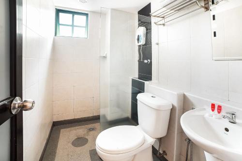 a white bathroom with a toilet and a sink at Dancenter Seremban Near Gateway Mall Formerly Sri Mutiara Hotel in Seremban