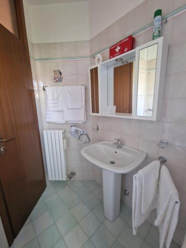 a bathroom with a sink and a mirror and towels at Il Glicine di Marco Polo in Cavallino-Treporti