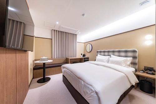 a hotel room with a bed and a television at Yongin IPPDA Petite in Yongin