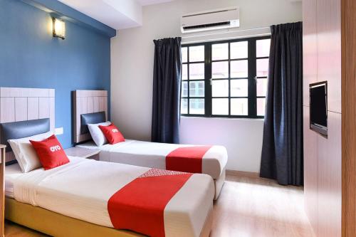 a hotel room with two beds and a window at Dancenter Seremban Near Gateway Mall Formerly Sri Mutiara Hotel in Seremban