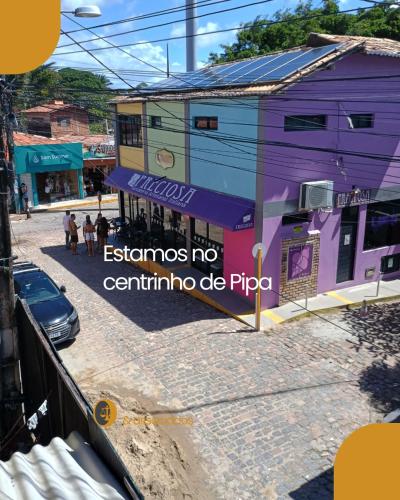 a colorful building on a street with a car at Flats Mundos Pipa in Pipa