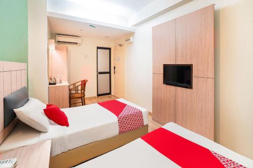 a hotel room with two beds and a flat screen tv at Dancenter Seremban Near Gateway Mall Formerly Sri Mutiara Hotel in Seremban