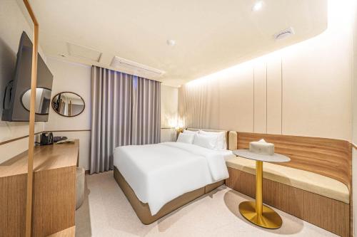 a hotel room with a bed and a table at Yongin IPPDA Petite in Yongin