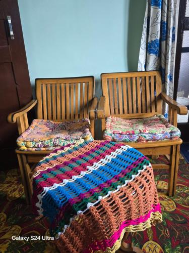 a crocheted blanket on a bed in a room at Rooftop Homestay With Mountains View in Panuānaula