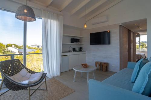 a living room with a couch and a table and a tv at Anastasio Hotel & Beach Club in José Ignacio
