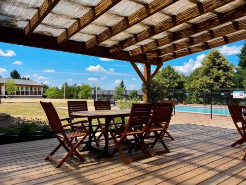 una terrazza in legno con tavolo e sedie in legno di Glynns at Club Correze a Meymac