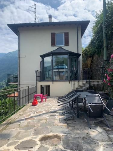 a house with a table and a balcony at Top Lake View in Faggeto Lario 