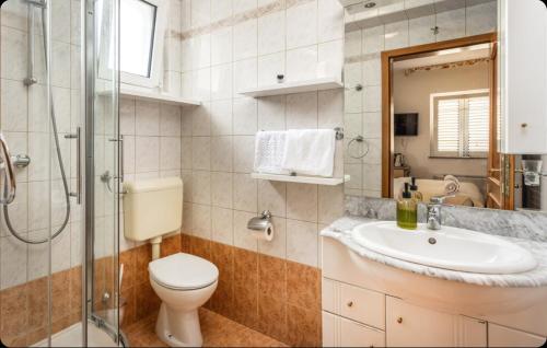 a bathroom with a toilet and a sink and a shower at Villa Ana Selce Soba s Kupaonom in Selce
