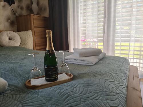 a bottle of champagne and two glasses on a bed at Srnčí vrch in Batňovice