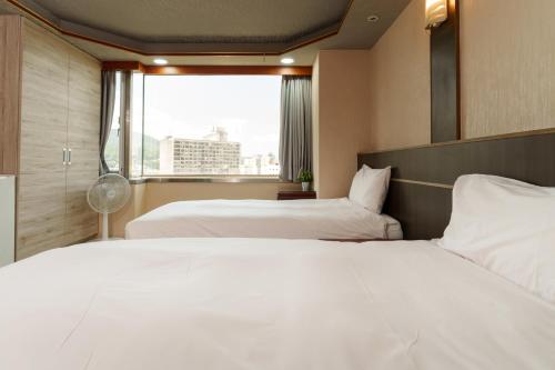 Postel nebo postele na pokoji v ubytování Love River Inn 愛河日央
