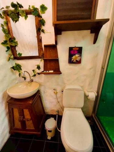 a small bathroom with a toilet and a sink at Plumeriahome near Chiangmai Airport in Chiang Mai