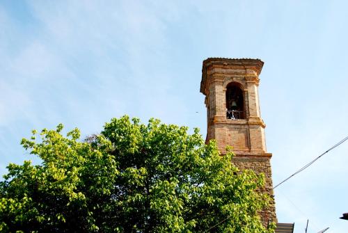a bell tower with a tree in front of it at B&B Le Ginestre in Collestrada