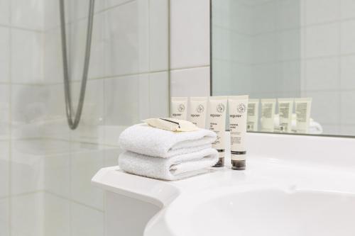 a pile of towels on a bathroom counter in front of a mirror at ☆of Southbank☆Light filled apartment☆HUGE private terrace with city views☆Parking☆Pool☆Gym☆WiFi in Melbourne