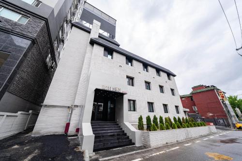 a white building with a staircase in front of it at Yongin IPPDA Petite in Yongin