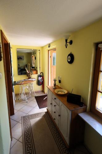 a kitchen with yellow walls and a table in a room at Cottage Sächsische Schweiz in Pirna