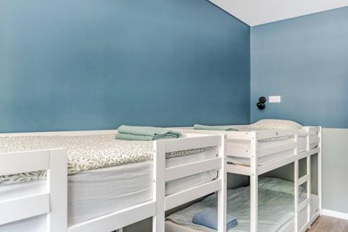 a bedroom with two bunk beds and a blue wall at Refreshed apartment with private garden in Almada