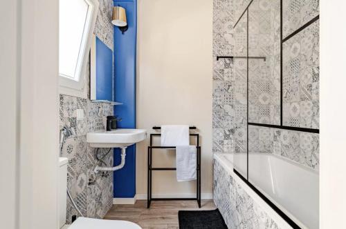 a bathroom with blue walls and a sink and a tub at Refreshed apartment with private garden in Almada