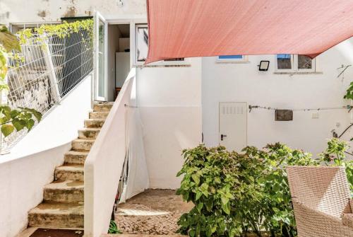 a staircase leading up to a white building with a red roof at Refreshed apartment with private garden in Almada