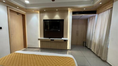 a bedroom with a flat screen tv and a bed at Hotel Time Square -Gandhiji Road, Old Bus Stand, Opp clock Tower ,Thanjavur in Thanjāvūr