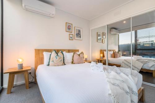 a bedroom with two beds and a large window at ☆of Southbank☆Light filled apartment☆HUGE private terrace with city views☆Parking☆Pool☆Gym☆WiFi in Melbourne