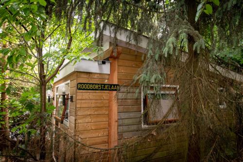 a wooden out house with a sign on it at B&B de Hinne in Holten
