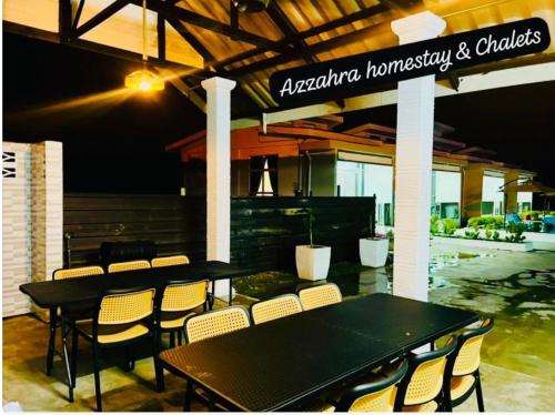 a restaurant with a black table and chairs at Azzahra Homestay & Chalet in Temerloh