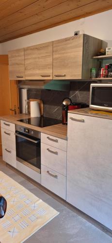 a kitchen with a stove and a microwave at Ferienwohnung Ingrid in Radmer an der Hasel
