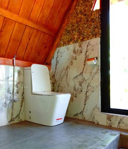 a bathroom with a toilet in a room at Ella Shia Cabana in Badulla