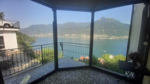 a room with a view of the water and mountains at Top Lake View in Faggeto Lario 