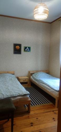 Un dormitorio con dos camas y una lámpara de araña. en Pumpuri apartment, en Jūrmala