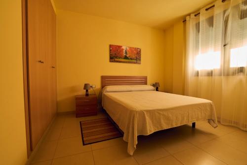 a yellow bedroom with a bed and a window at Apartamento Céntrico in Amposta