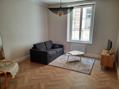 a living room with a couch and a table at La belle Alliance in Beaugency
