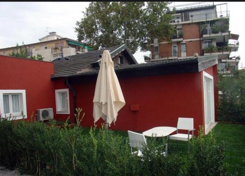 a red house with a table and an umbrella at Villa fronte mare Venezia Lido in Venice-Lido