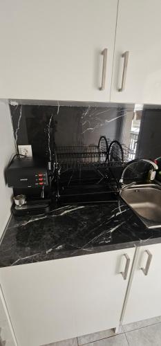 a kitchen counter top with a stove and a sink at Julsun apartment in Olympiaki Akti