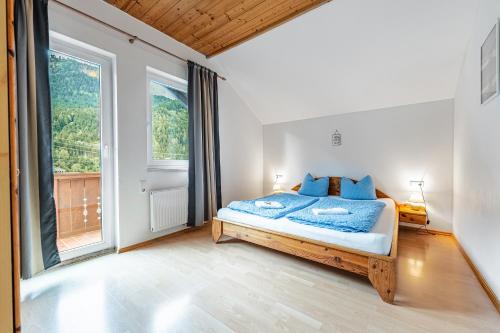 a bedroom with a bed and a large window at Haus Edelweiss Mölltal in Flattach