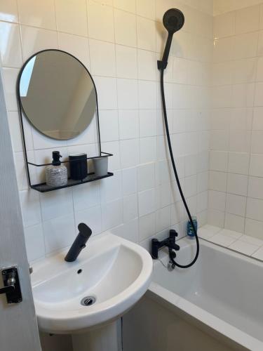 a bathroom with a sink and a shower with a mirror at Tranquil Thamesmead Treasure - London in Thamesmead