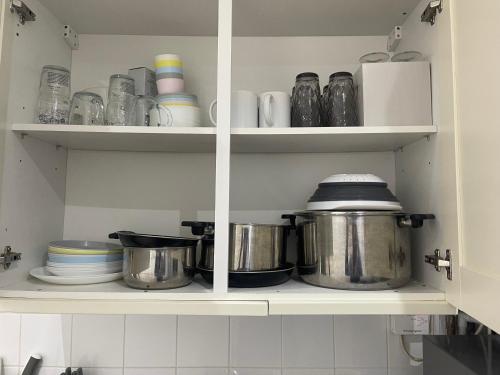 a kitchen cabinet filled with pots and pans at Tranquil Thamesmead Treasure - London in Thamesmead
