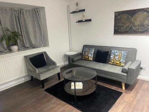 a living room with a couch and a chair at Tranquil Thamesmead Treasure - London in Thamesmead