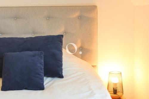 a bed with blue pillows in a bedroom at COC - La Brise Marine in Wissant