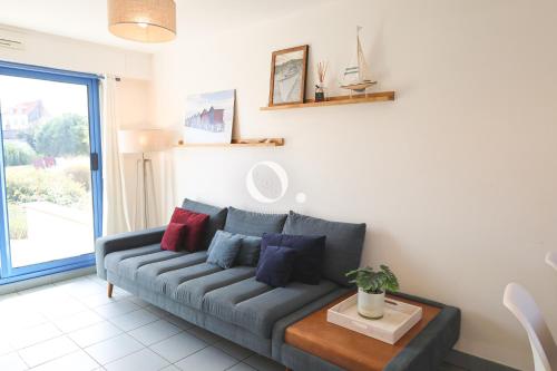 a living room with a gray couch and a table at COC - La Brise Marine in Wissant