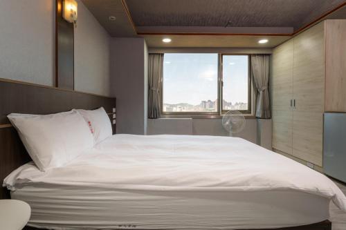 Postel nebo postele na pokoji v ubytování Love River Inn 愛河日央
