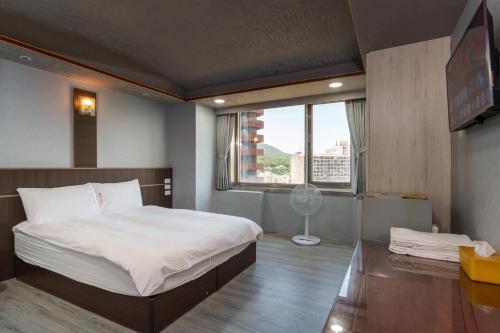 Postel nebo postele na pokoji v ubytování Love River Inn 愛河日央