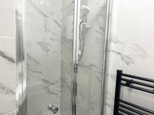 a shower with a glass door in a bathroom at Harrow Haven - Sleeps 5 & Free parking in Harrow