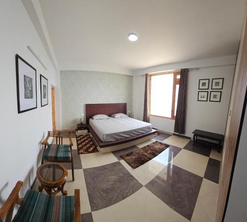 a bedroom with a bed and a checkered floor at The Hill Crest, Fagu in Shimla