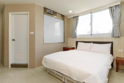 Postel nebo postele na pokoji v ubytování Love River Inn 愛河日央